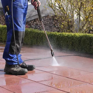 A pressure washer cleaning a patio